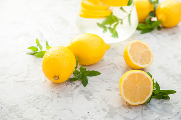 Homemade refreshing lemonade in decanter close-up and copy space. Lemonade from lemons, mint, ice.