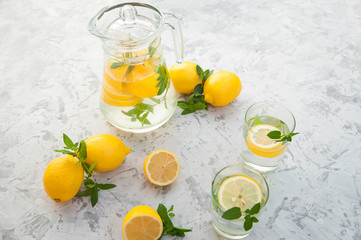 Homemade refreshing lemonade in decanter close-up and copy space. Lemonade from lemons, mint, ice.