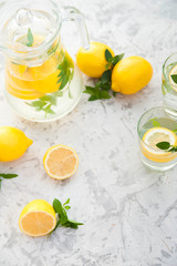 Homemade refreshing lemonade in decanter close-up and copy space. Lemonade from lemons, mint, ice.