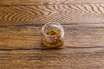 Zucchini pate in glass jar isolated on wooden background