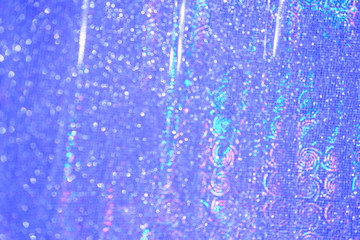 Blurred bokeh light blue holographic background, Christmas and New Year holidays background. Party concept. Festive holiday bright backdrop. Defocused.