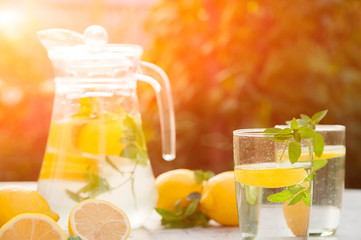 Homemade refreshing lemonade in decanter close-up and copy space. Lemonade from lemons, mint, ice.