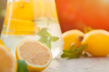 Homemade refreshing lemonade in decanter close-up and copy space. Lemonade from lemons, mint, ice.