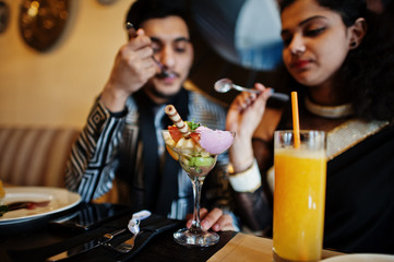 Lovely indian couple in love, wear at saree and elegant suit, posed on restaurant.