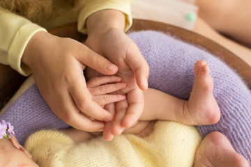 newborn . the sister hold hands. the hands of newborn children