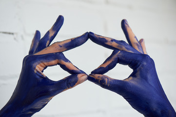 Hands in blue paint, the hands of the artist and creative person. Yoga for the hands.