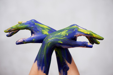 Hands in blue paint with yellow accents, hands of the artist and creative person. Yoga for hands