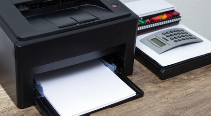 Laser printer and office supplies on the table.