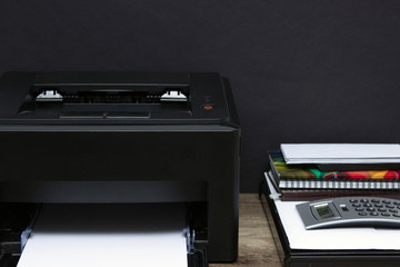 Laser printer and office supplies on the table.