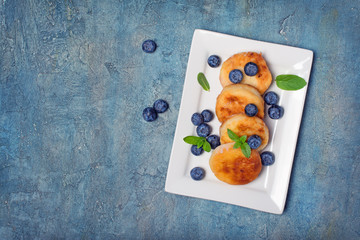 Fototapeta na wymiar Cottage cheese pancakes with blueberries on white plate