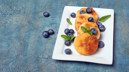 Cottage cheese pancakes with blueberries on white plate