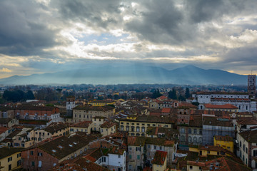 Fototapeta na wymiar Raggi di sole fra le nuvole sui tetti di Lucca