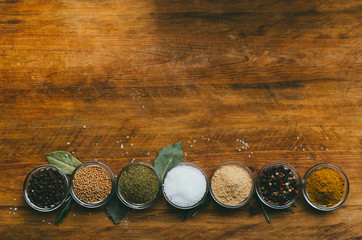 Variety of spices in round glass bowls - ground ginger, hops-suneli, kari, black pepper and mix