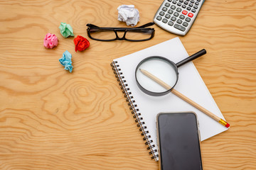 top view book , calculator, glasses on wooden table.