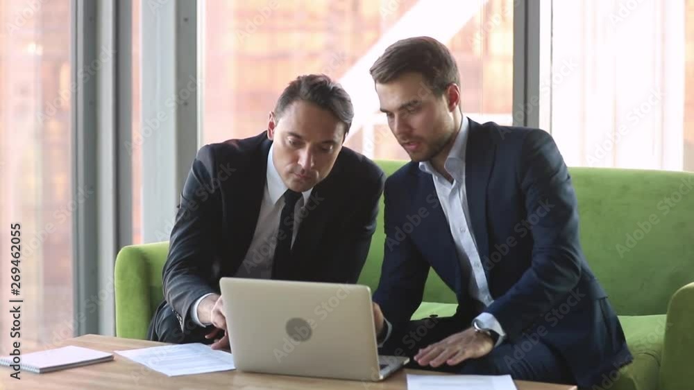 Wall mural Male broker consulting client with laptop handshake make deal