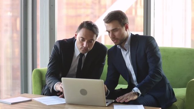 Male broker consulting client with laptop handshake make deal