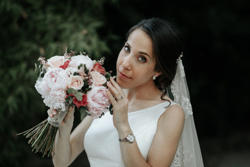 Happy and smiling bride in luxury dress with wedding bouquet