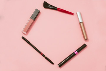 Cosmetics on pastel background. Mascara, lipstick, pencil, brush for applying makeup on a plain background. Flatlay, copyspace.