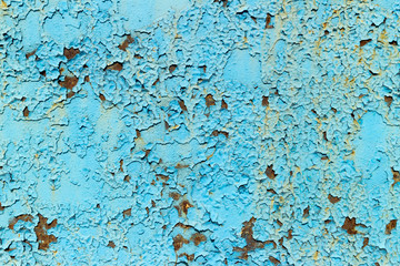 Rusty metal surface painted with peeling blue paint
