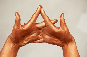 Hands in gold paint, the hands of the artist and creative person. Yoga for hands