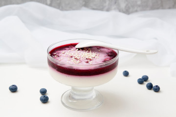 Creamy Blueberry jelly and sesame in glass vase with white spoon