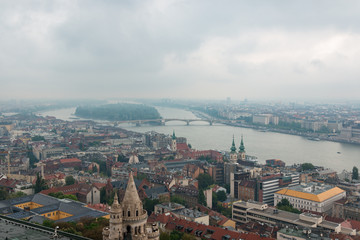 Budapest, Hungary. View of the city in cloudy weather from the tower of the Cathedral of St. Matthias. Danube River. Spring. Tourism and travel. Skyview. Top view.