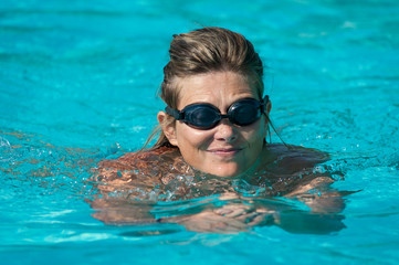 Caucasian woman trains in the pool, swimming and practicing aquagym to stay healthy