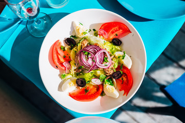 salad with fresh vegetables and quail eggs. top view