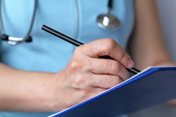 Medical exam, woman doctor or nurse with stethoscope writes a prescription paper. Concept of...