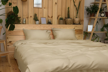 Real photo of a botanical bedroom interior with wooden shelves,  double bed and plants. Bedroom wooden interior with plants next to a bed made with pillows.