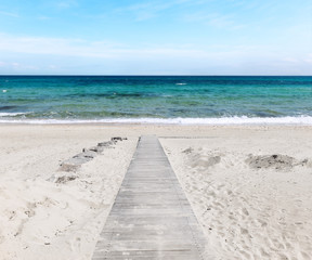 Fototapeta na wymiar Wooden path on the sandy beach