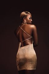 rear view of fashionable african american woman with short hair isolated on brown