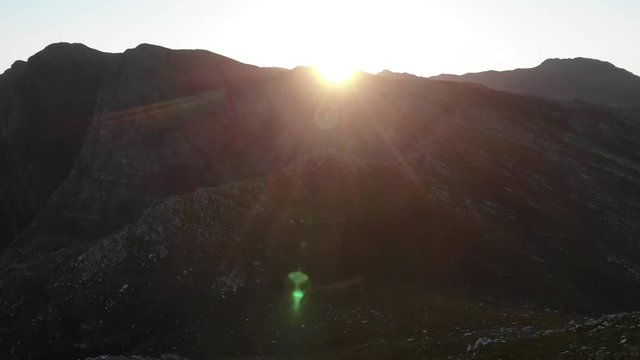 Aerial footage of sunrise over a rugged mountain valley