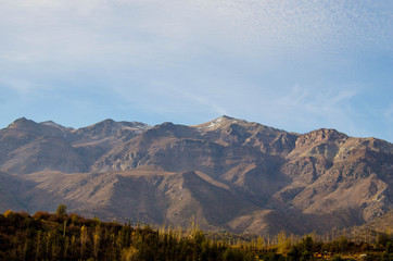 mountain view during the daytime. mountains, valley, clouds, reflection from the clouds on the mountains, forest, summer, autumn forest in the mountains. in the distance house and reservoir, artificia