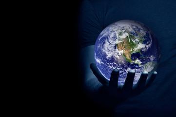 Hand holding a globe on black background