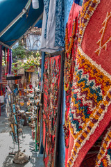 Carpets, crafts and souvenirs exhibited in a street of Chefchaouen (or Chaouen), Morocco.