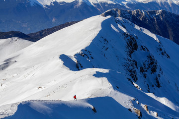 3 mountain climbers walk on snow in the mountains