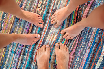Top view image of feet of young people standing in a circle. Mixed race friends standing barefoot...