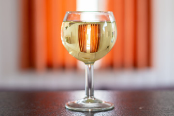 Glass of white maybowl standing on a sideboard in front of a window with sunsshine in the living room