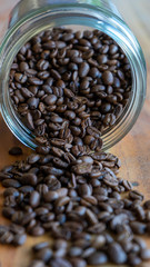 coffee beans spilled against a wooden table background