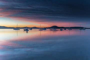 Fototapeta na wymiar High Clouds, Boats, Reflections and Sunrise on the Bay