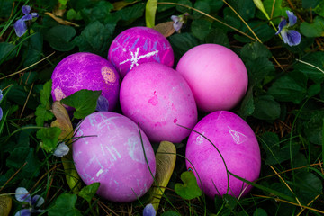 a group of vibrant painted easter eggs in the grass