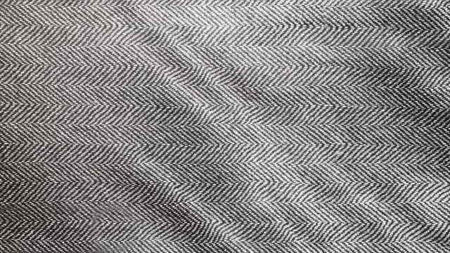 Herringbone background, macro shot of tweed fabric cloth waving. 