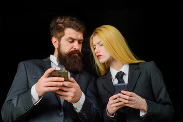 People working mobile devices. Business team working on smartphones. Handsome businessman&businesswoman with mobile phone. Business couple chatting with mobile phone. Businessperson using smartphones.