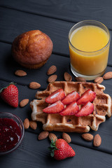 Traditional belgian waffle with strawberry. Sweet homemade breakfast. Delicious. Dessert on black table background
