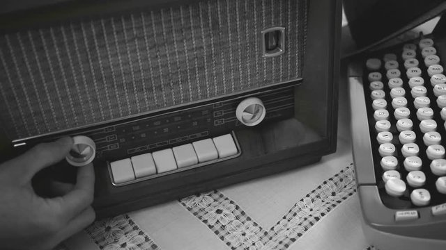 Using an old tube radio. 50's 60's 70's vintage scene. Historical reenactment concept.