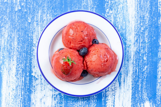 plate of pink strawberry ice cream frresh berry znd mint isolated on white