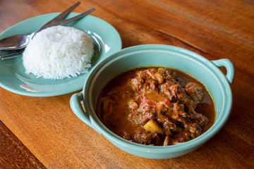 Beef massaman curry with rice on wooden table, Thai food