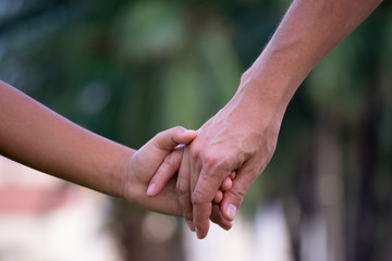 Close up of father and a child hands at the sunset with copy space. Love concept or family concept.