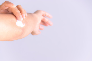 Healthcare concept. Close Up shot of young woman hands applying moisturizing body cream to her elbow with copy space for advertisers.